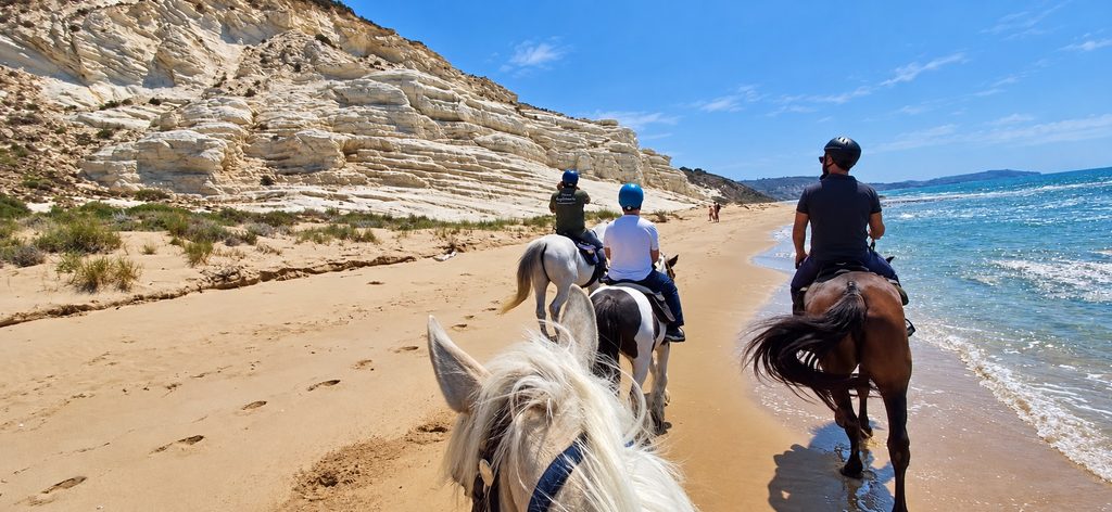 Passeggiata a cavallo sulla spiaggia, sotto la scogliera bianca